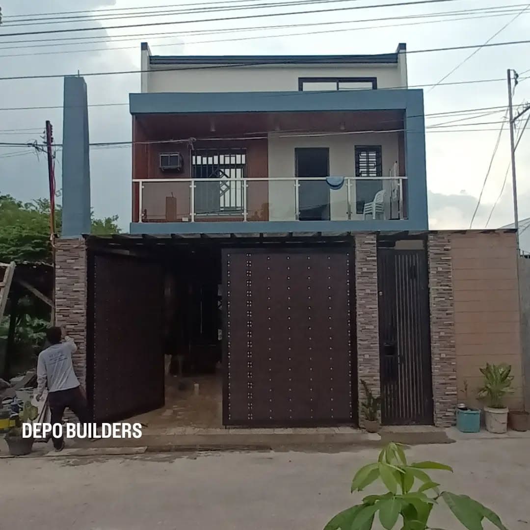 Completed two-storey house with a steel gate and stone-clad columns