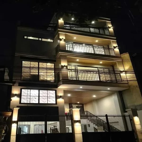 Multi-storey residential building at night with every balcony and soffit light switched on